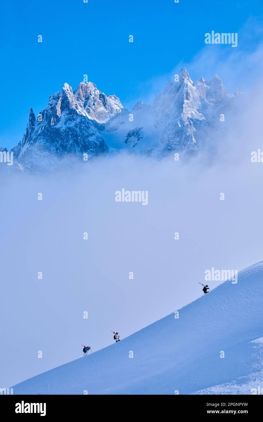 Skiers hiking on snow covered mountain Stock Photo