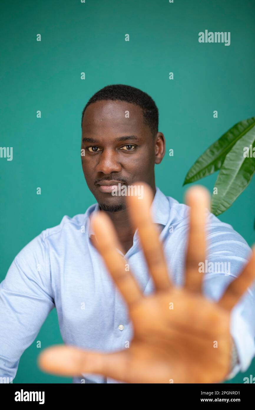 Businessman stop gesturing in front of wall Stock Photo