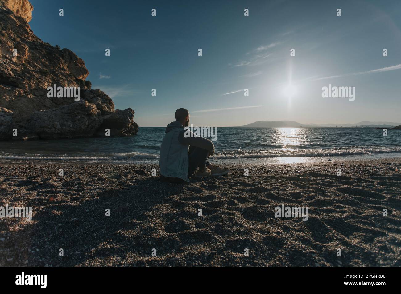Man sitting on rock shore hi-res stock photography and images - Alamy