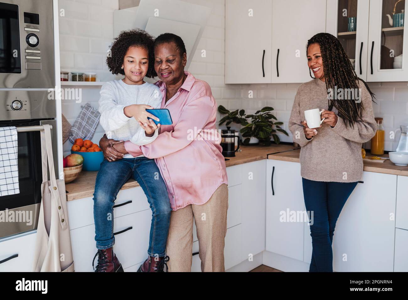 Family spending leisure time in kitchen at home Stock Photo