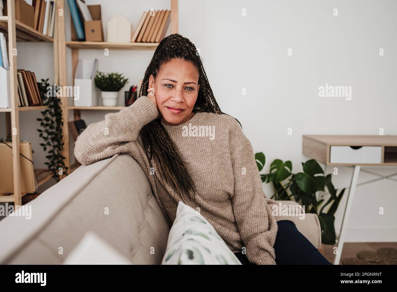 Smiling mature woman sitting on sofa at home Stock Photo - Alamy