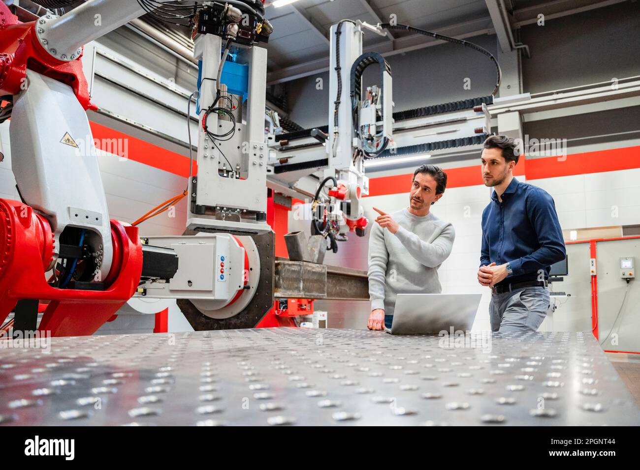 Technician explaining robot to engineer in factory Stock Photo Alamy