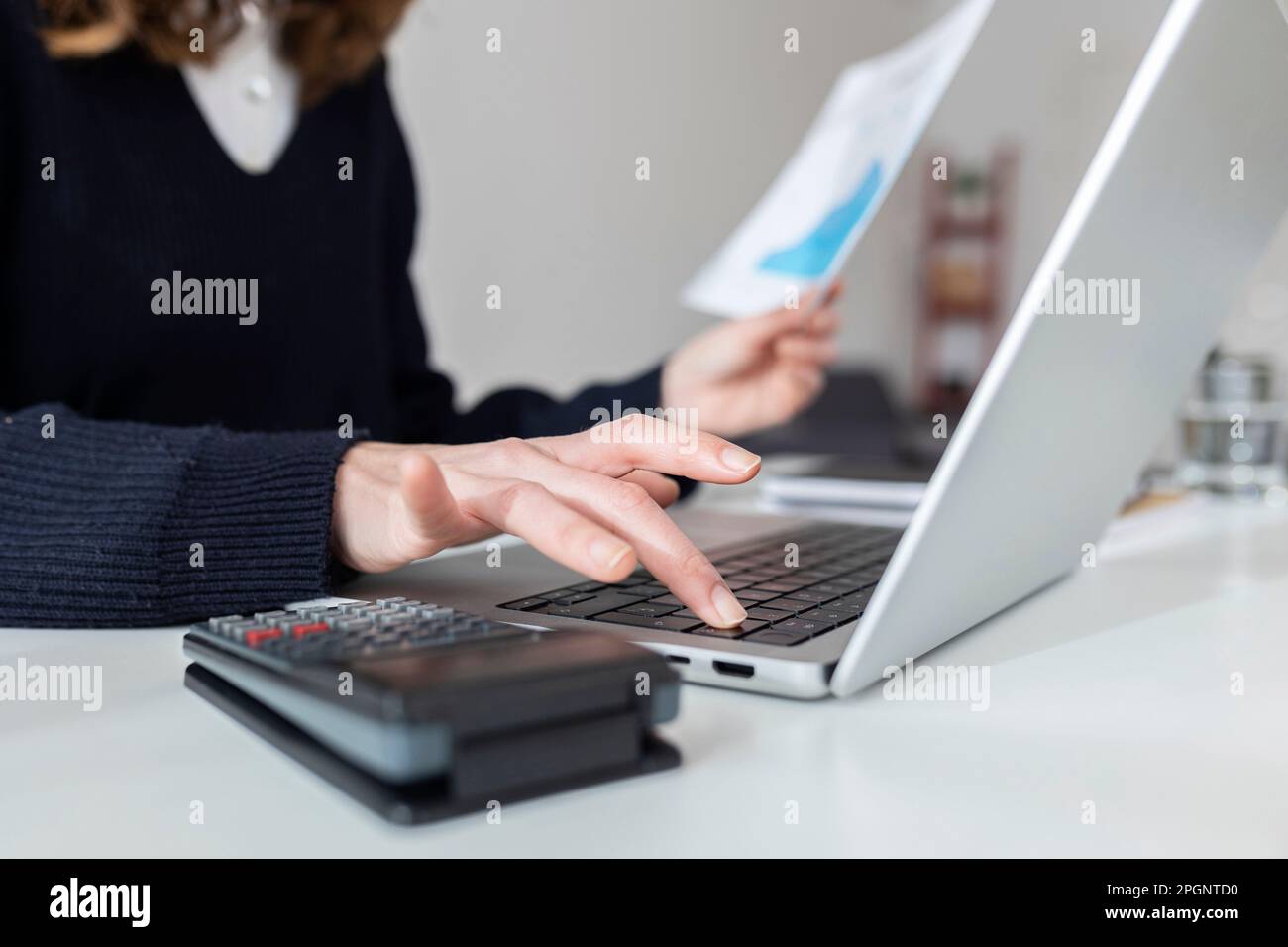 Businesswoman using laptop at desk Stock Photo