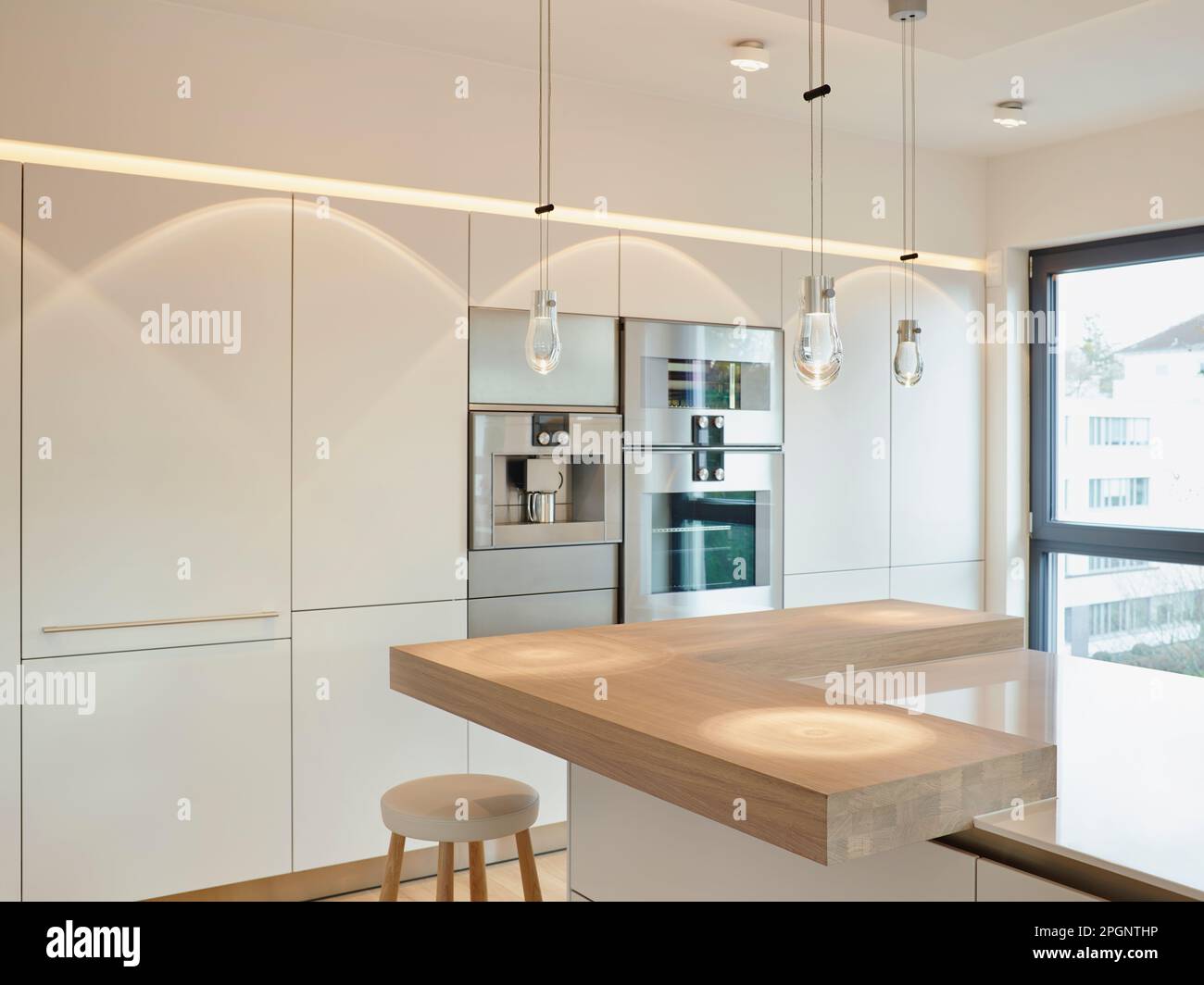 Pendant lights on kitchen island in modern apartment Stock Photo