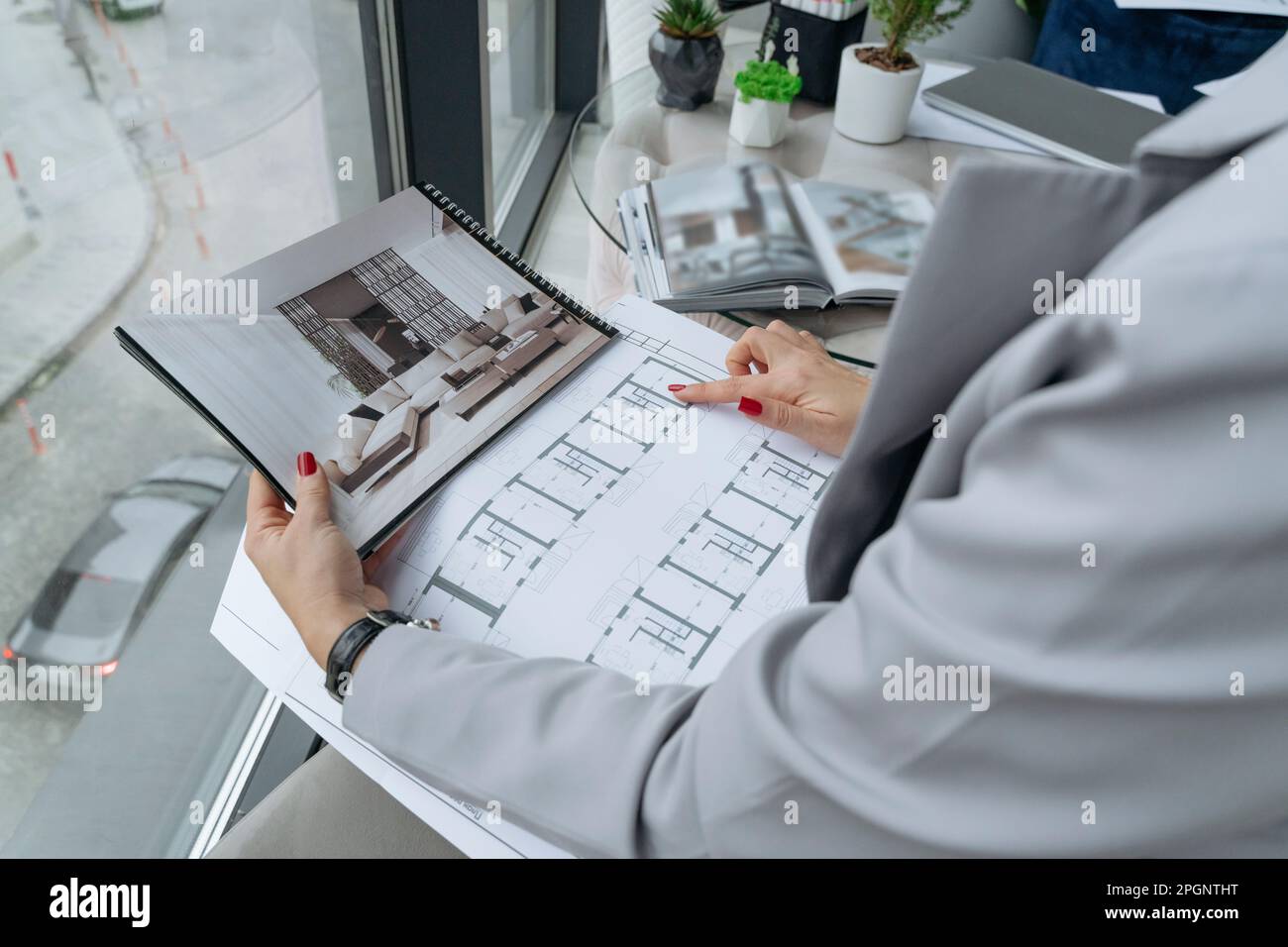 Interior designer examining blueprint at office Stock Photo - Alamy