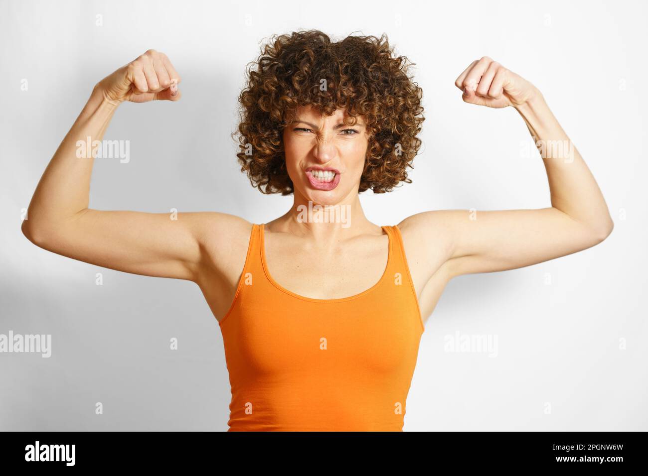 Woman flexing muscles against white background Stock Photo
