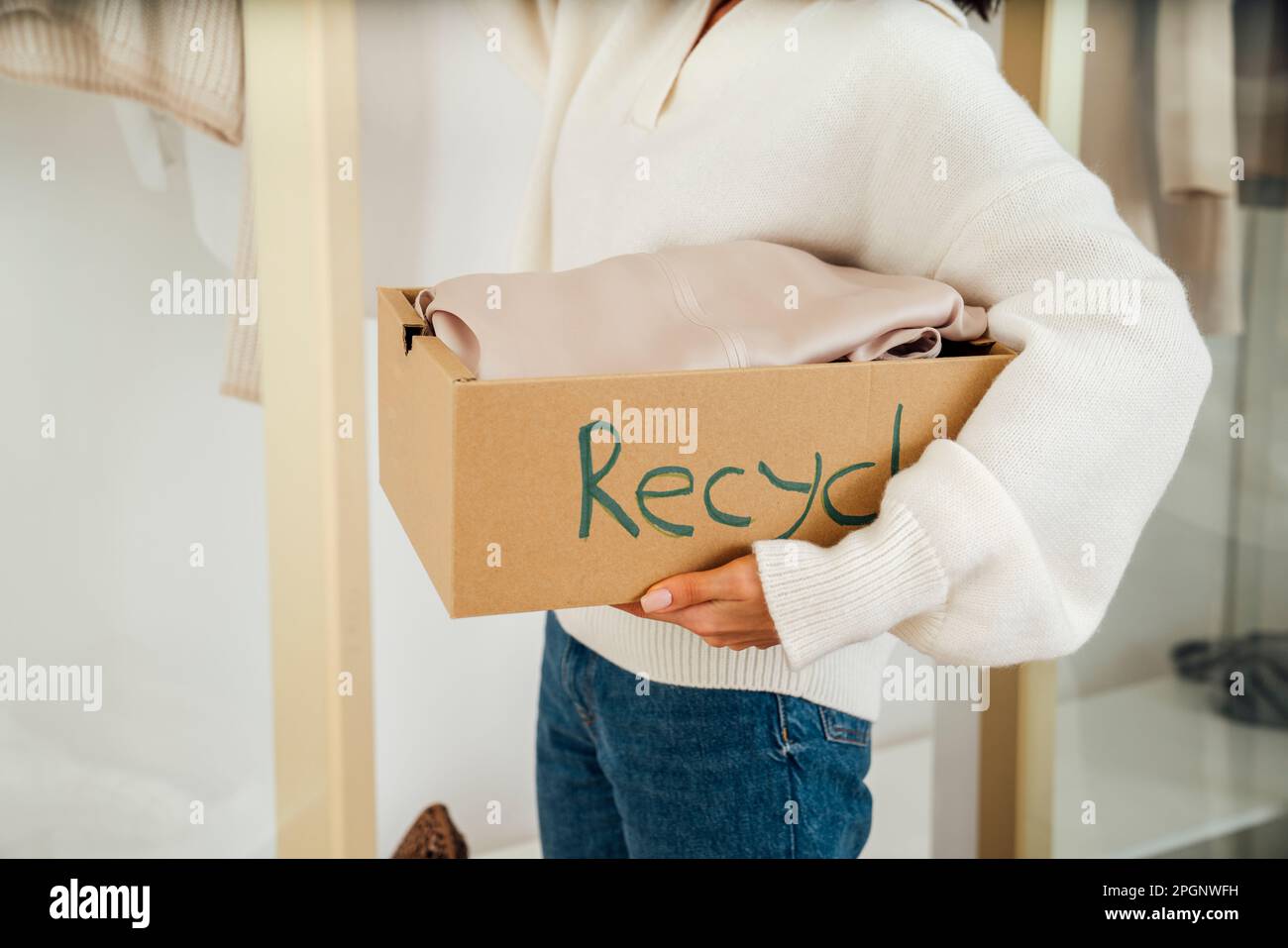Young woman with clothes in recycle box Stock Photo Alamy