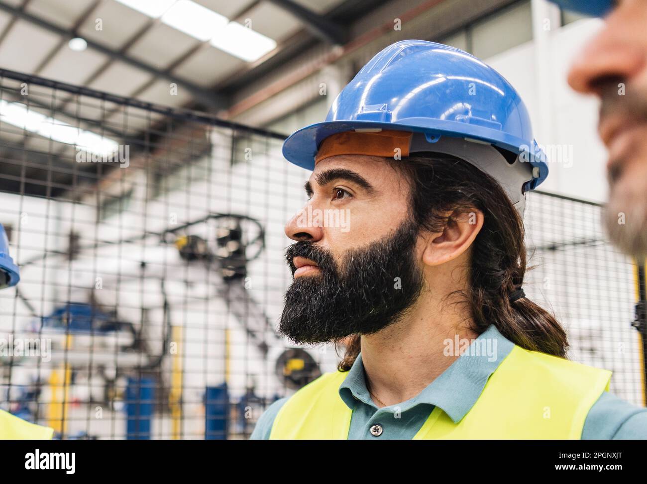 Thoughtful engineer with beard in factory Stock Photo