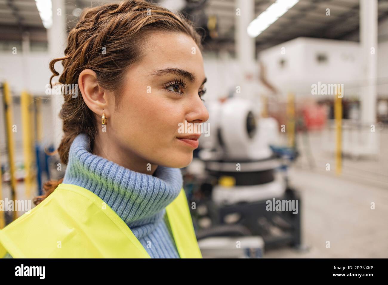 Thoughtful engineer wearing reflective clothing in factory Stock Photo