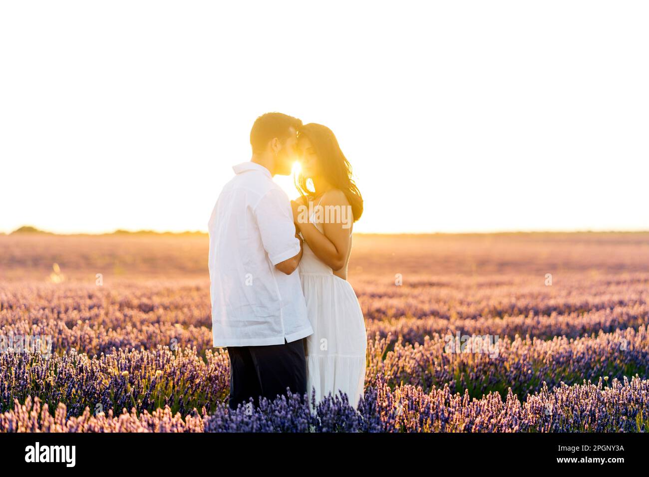 Affectionate man embracing young woman at sunset Stock Photo