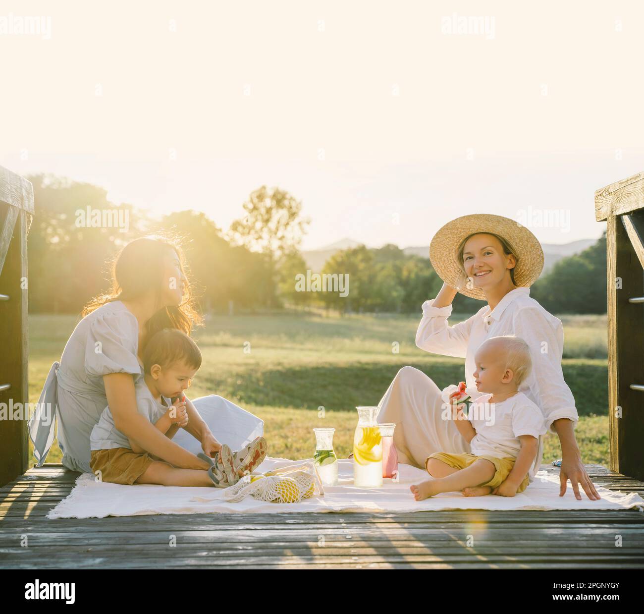 Smiling women with their sons spending time together at picnic Stock Photo