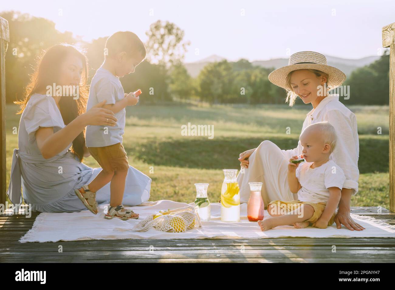 Women spending time together with sons at picnic Stock Photo