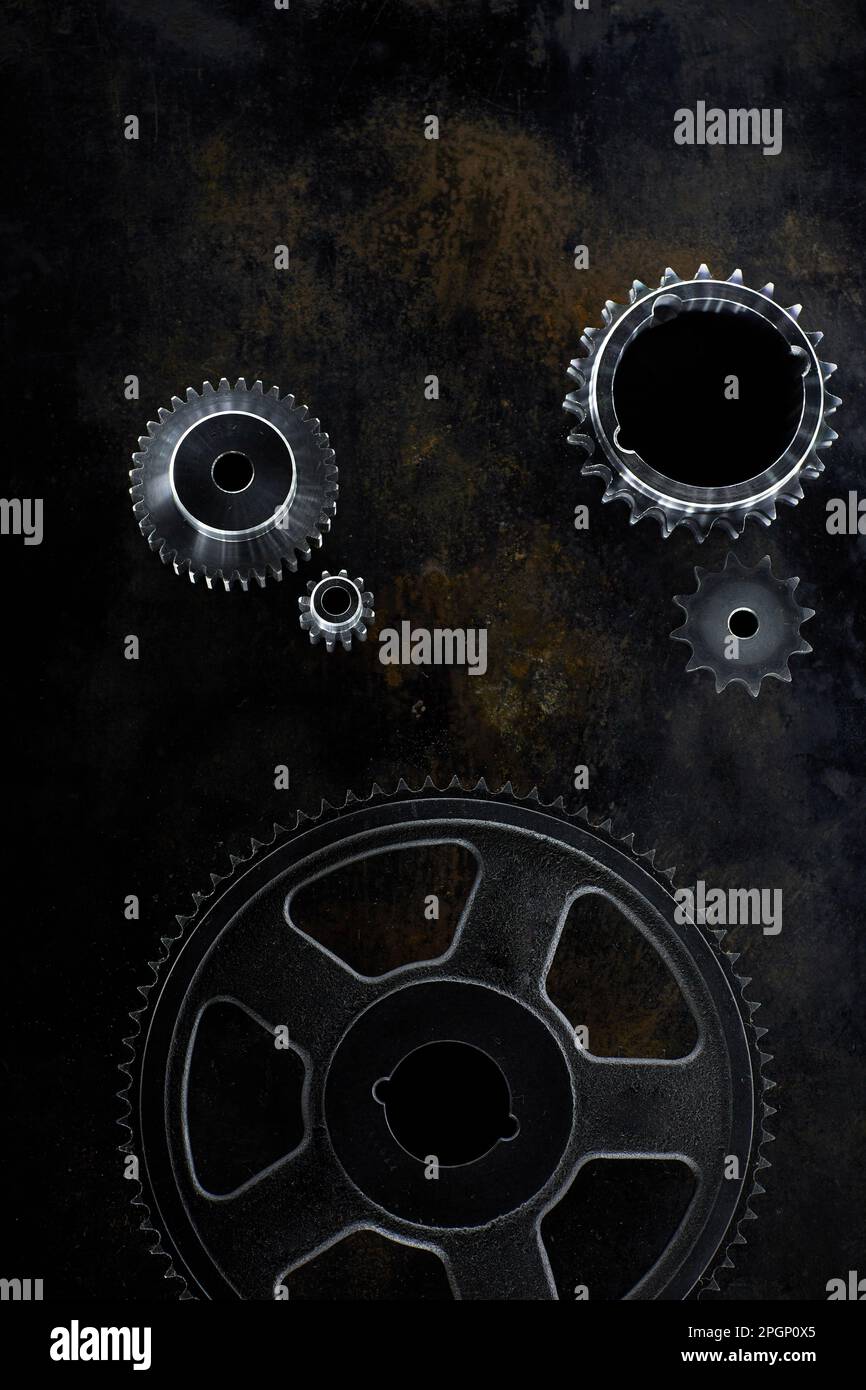 Metal gears lying on dark surface Stock Photo