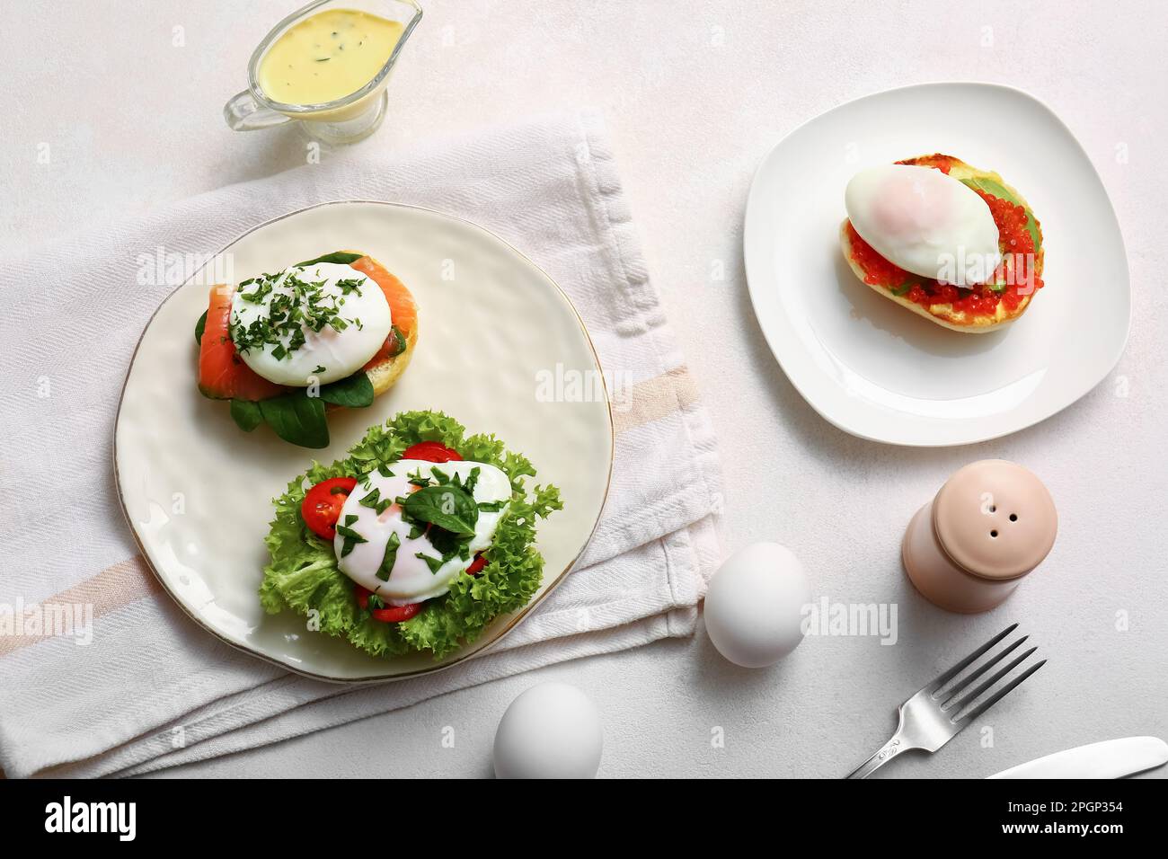 Plates with tasty eggs Benedict on white table Stock Photo