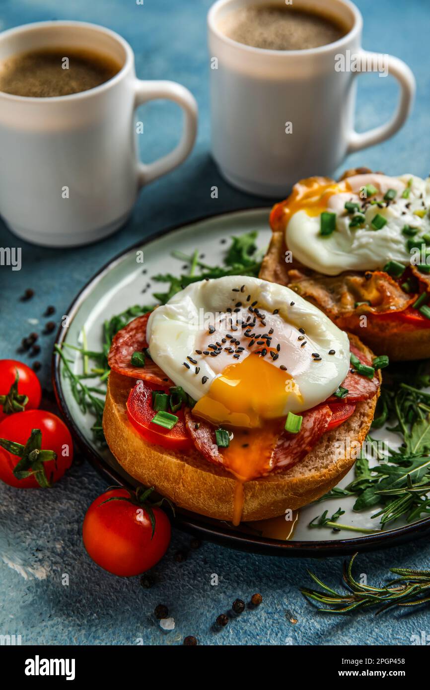 Plate with tasty eggs Benedict on blue background Stock Photo