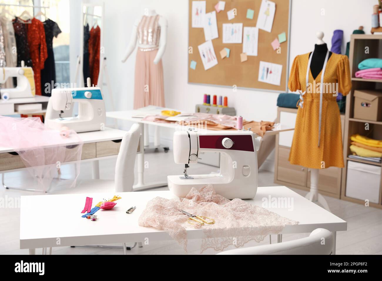 Dressmaking interior with stylish female clothes and equipment