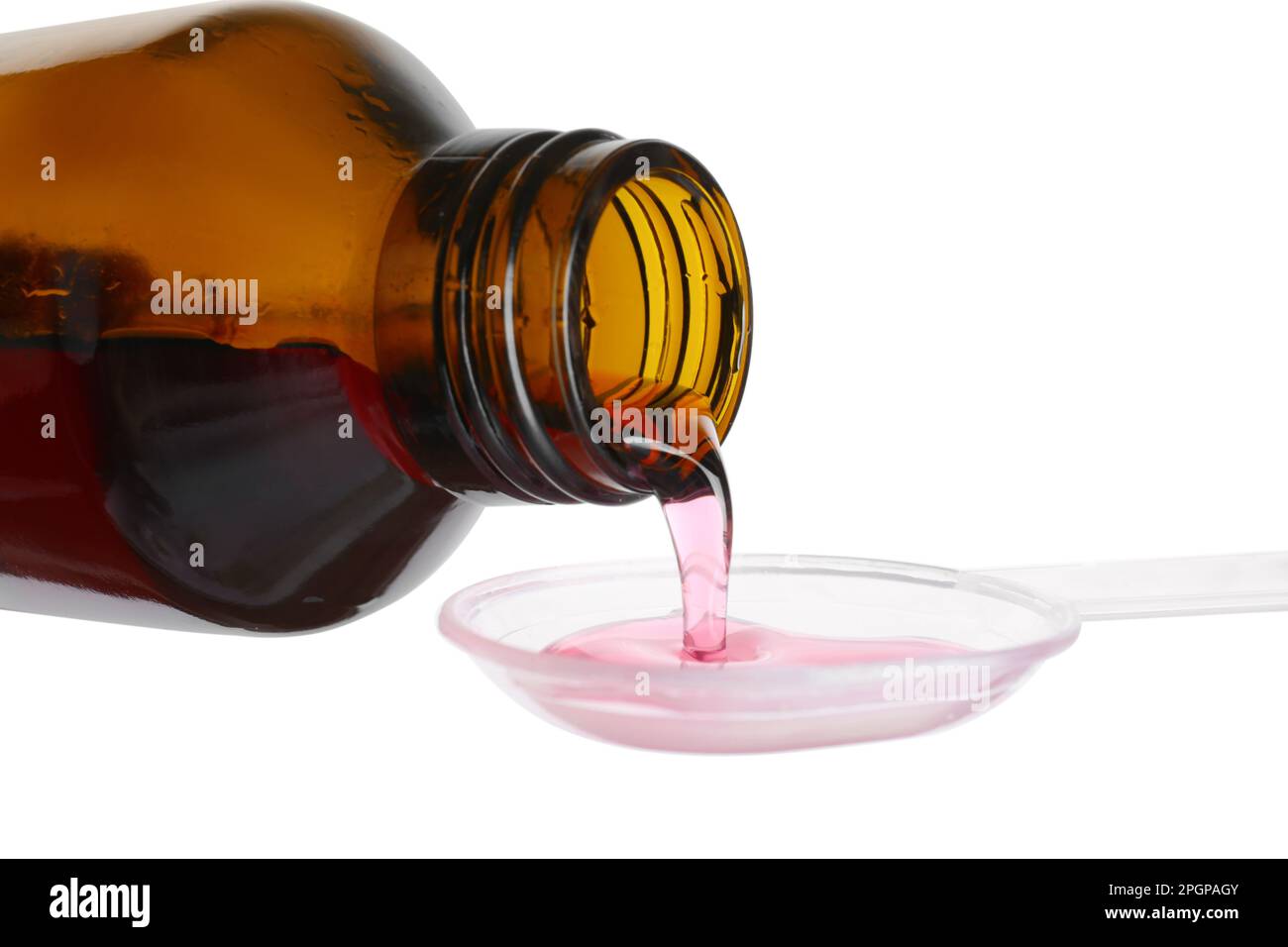 Pouring cough syrup into dosing spoon on white background Stock Photo