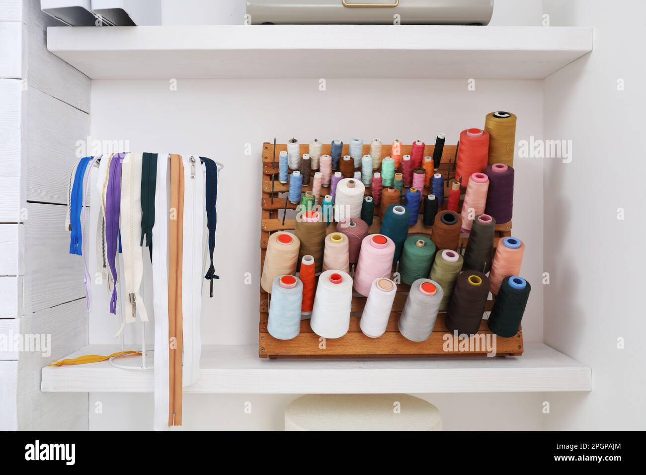 Wooden holder with collection of different threads on shelf in tailor studio Stock Photo Alamy