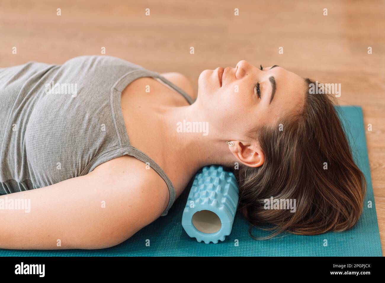 Girl kneading her neck with foam roller Stock Photo - Alamy