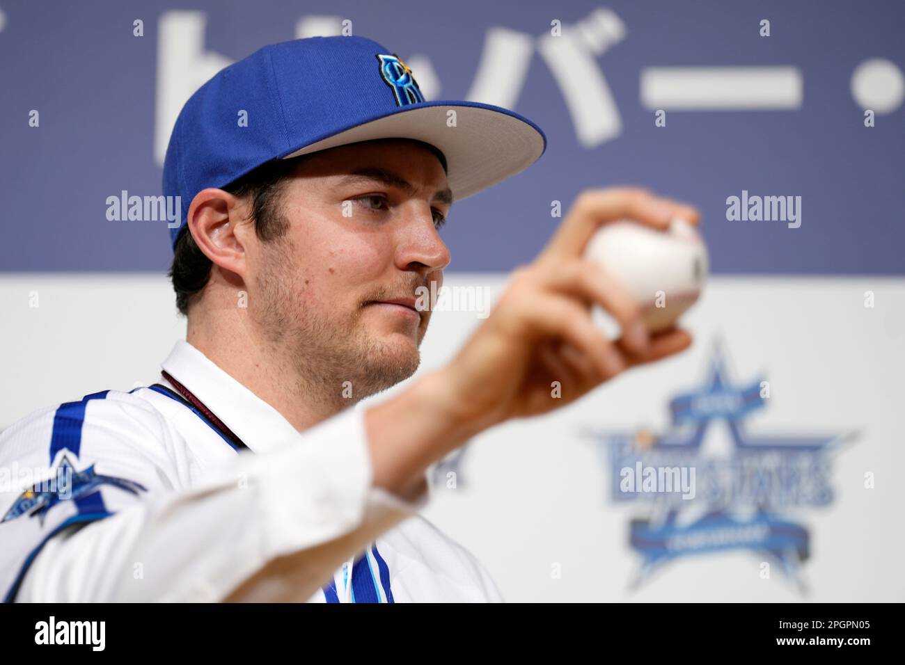 Trevor Bauer with his new uniform and cap of Yokohama DeNA BayStars poses  for photographers during a photo session of the news conference Friday,  March 24, 2023, in Yokohama, near Tokyo. (AP