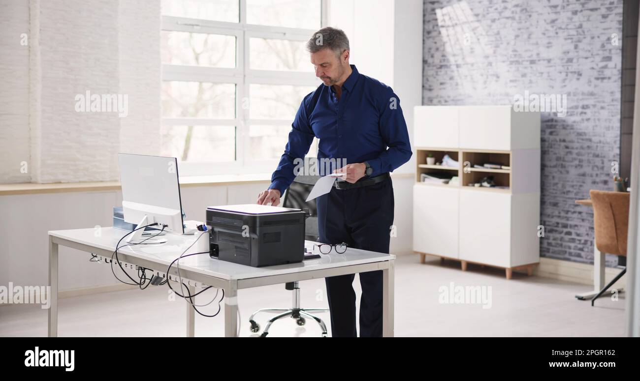 Man Using Photocopy Machine In Office. Printer And Copier Stock Photo