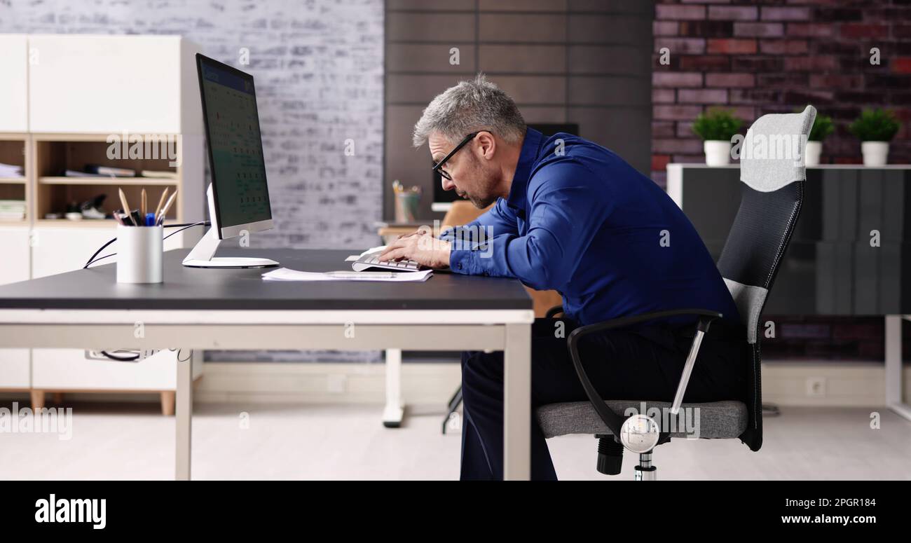 Bad Posture Sitting In Office Chair At Computer Desk Stock Photo - Alamy