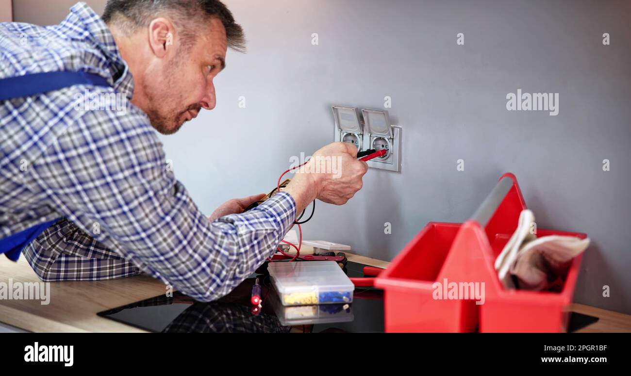 Male Electrician Checking Voltage Of Socket With Multimeter In House Stock Photo