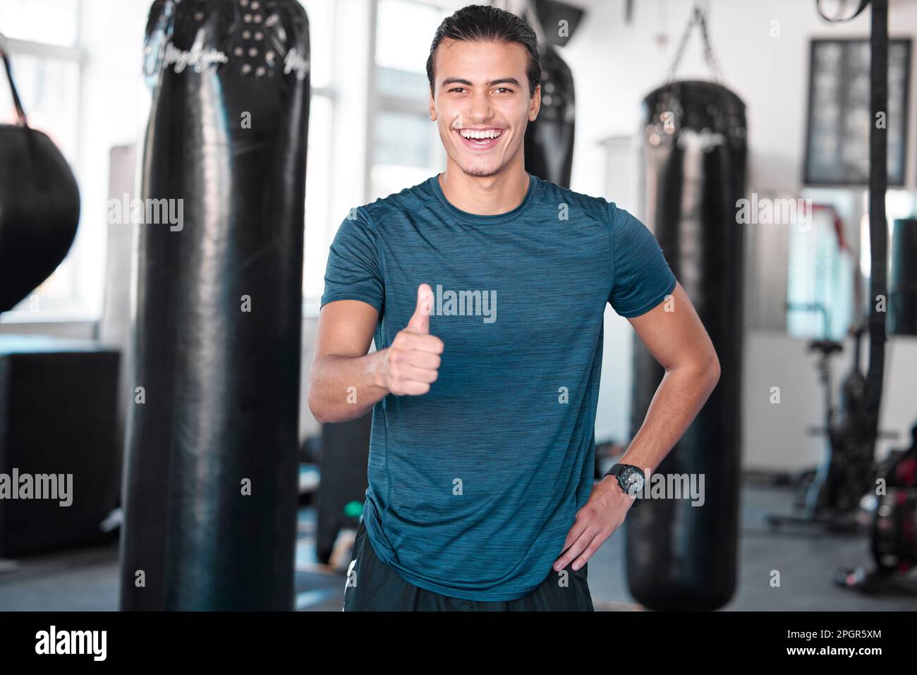 Laughing, thumbs up and portrait of man in gym for success, motivation