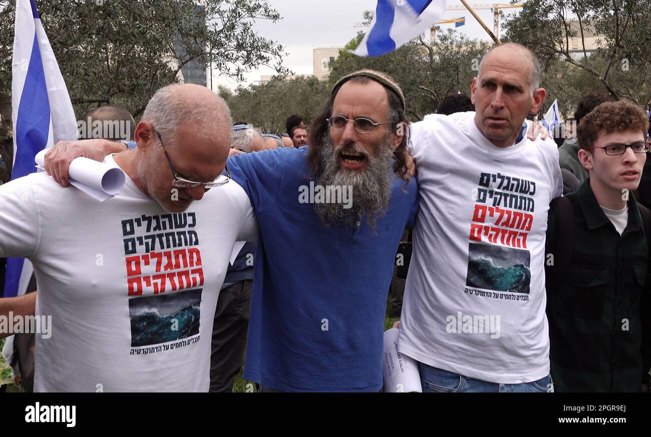 Anti government protesters sing with a religious Jew before taking part in prayer in a plea for unity and divine deliverance from rising tensions over the country’s judicial overhaul in front of the Israeli Supreme court on March 22, 2023 in Jerusalem, Israel. The Netanyahu government is pushing ahead with proposed overhaul of the judiciary that would limit the Israeli Supreme Court's ability to review and strike down laws that it deems unconstitutional. Stock Photo