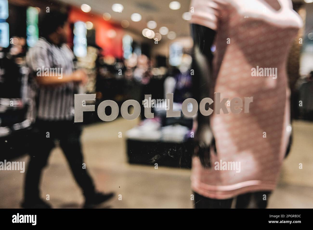 An exterior view of a Footlocker store, with its iconic black and white