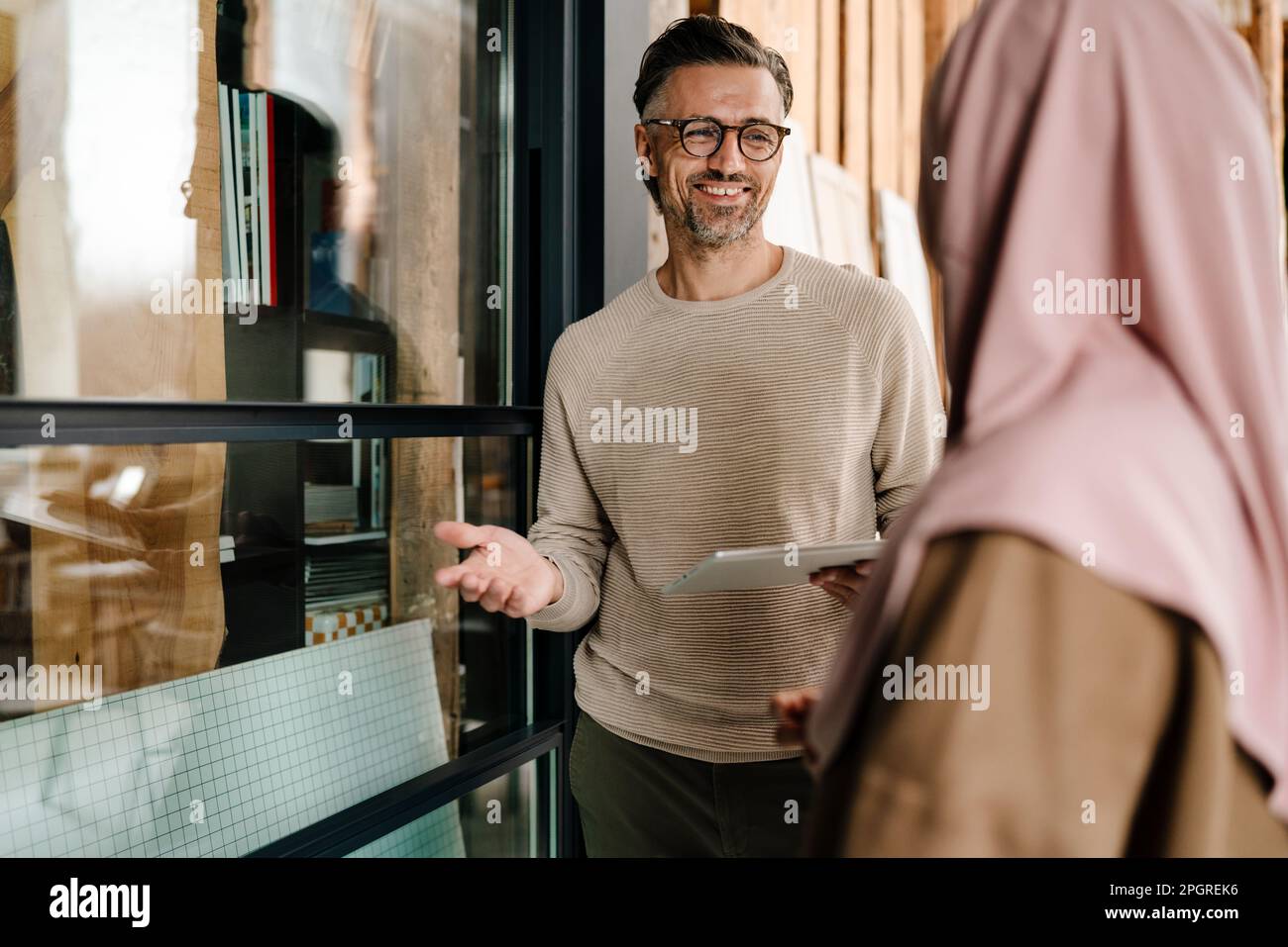 Two multiracial colleagues using tablet while working together in modern office Stock Photo