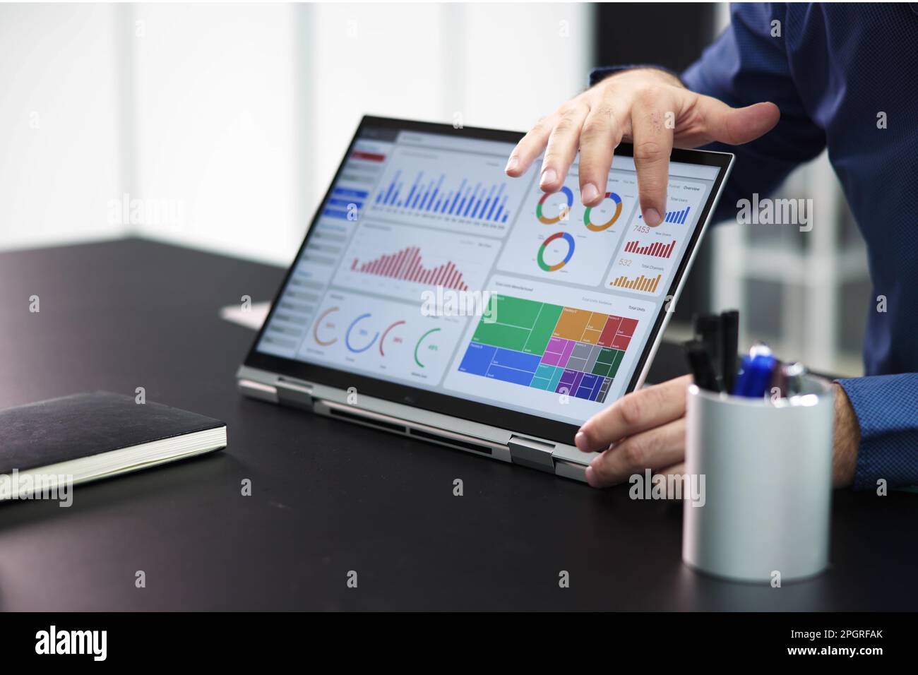 Two Businesspeople Analyzing Financial Graph On Laptop Stock Photo
