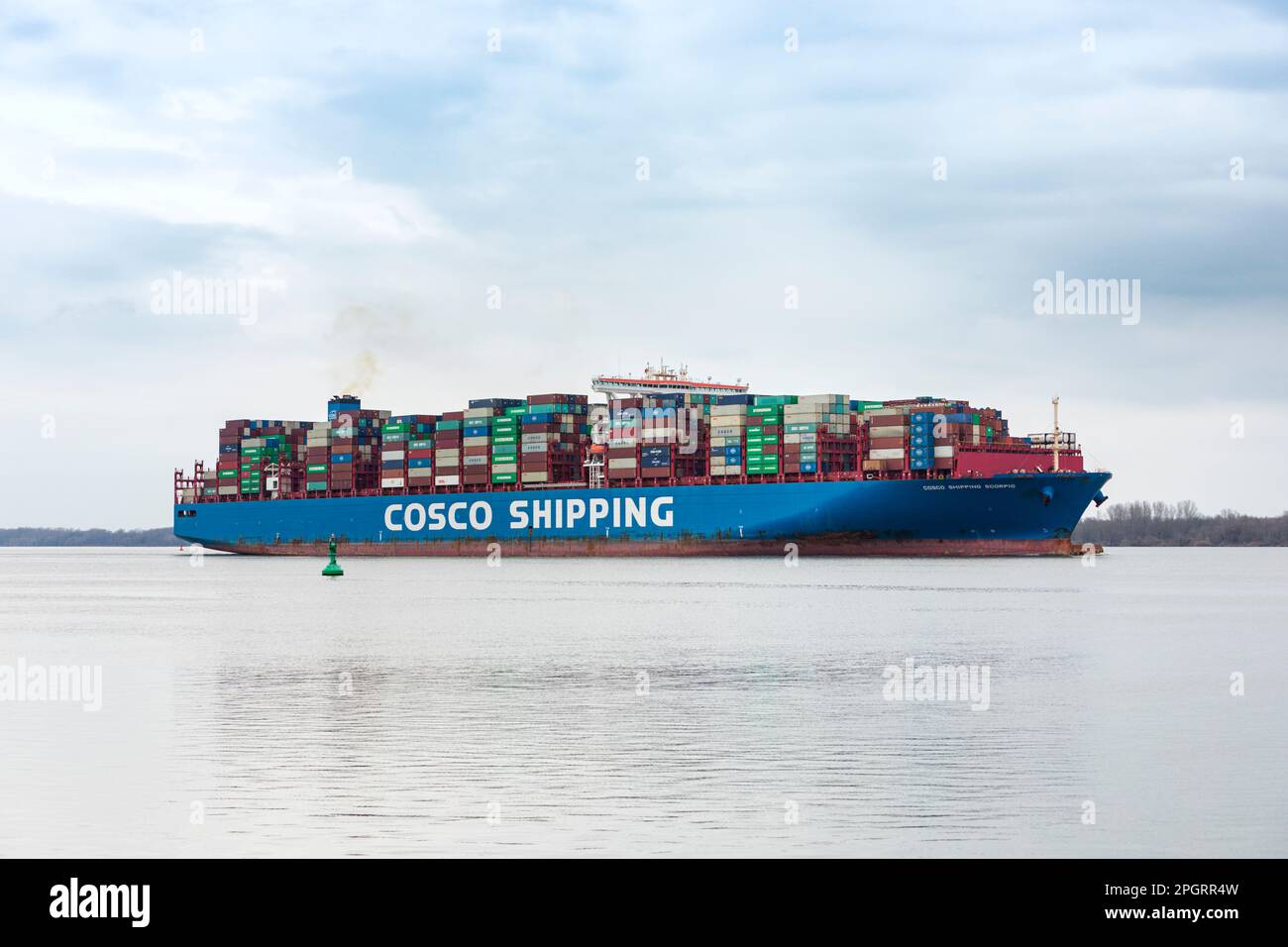 Stade, Germany – March 19, 2023: Container ship COSCO SHIPPING SCORPIO on Elbe river heading to Hamburg. Stock Photo