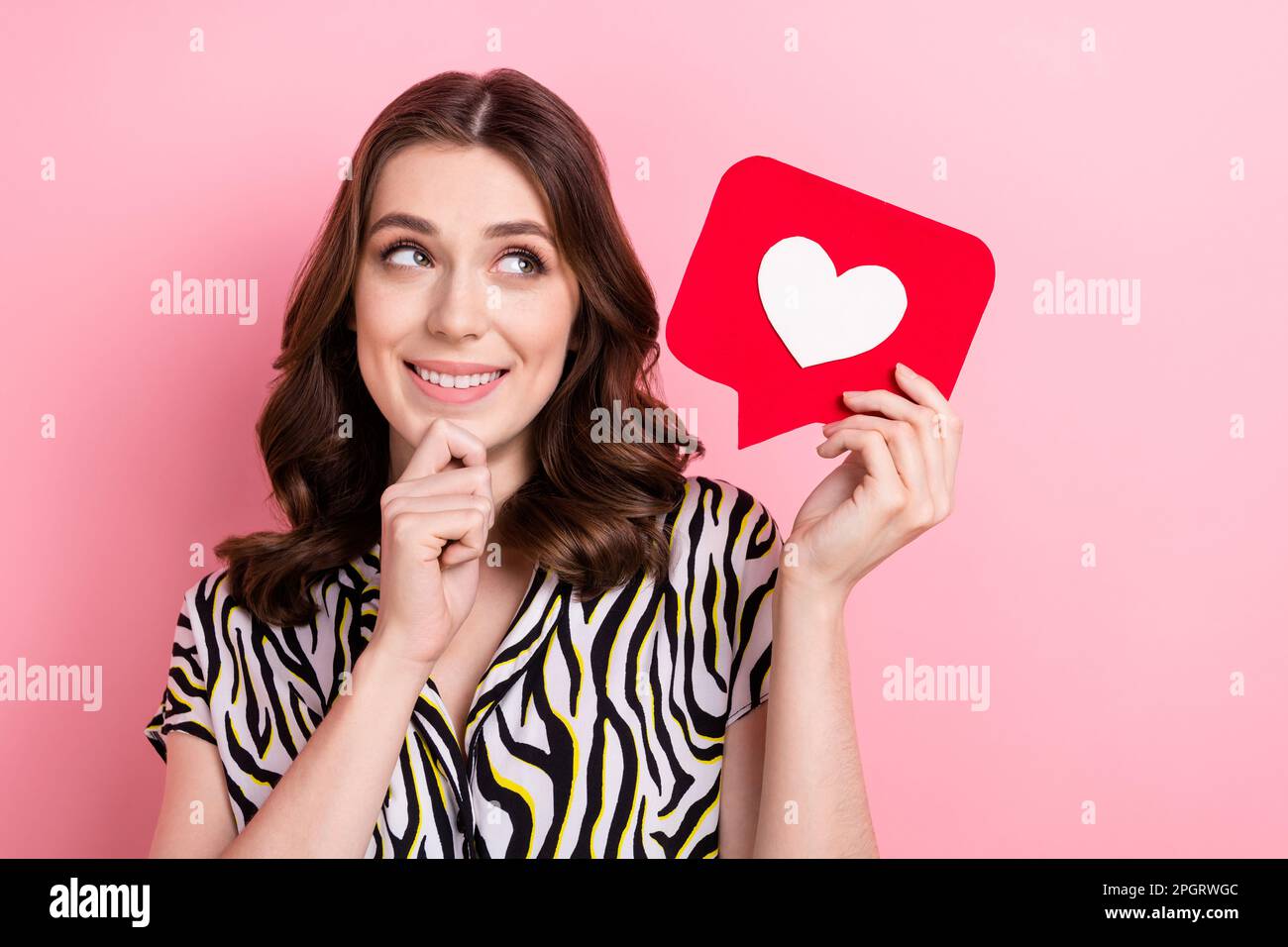 Portrait of young cute blogger famous person celebrity hold paper like notification think how make more followers isolated on pink color background Stock Photo