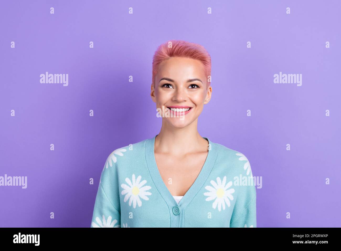 Photo of satisfied cute girlish woman with short hairstyle dressed blue cardigan look up empty space isolated on purple color background Stock Photo