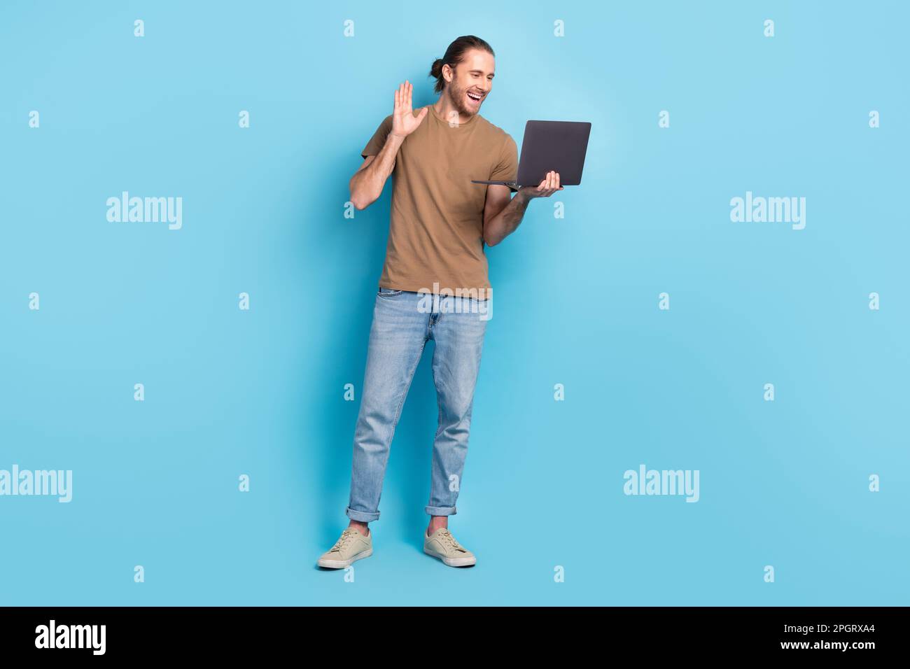 Full length photo of good mood cute guy dressed beige t-shirt video call modern device isolated blue color background Stock Photo