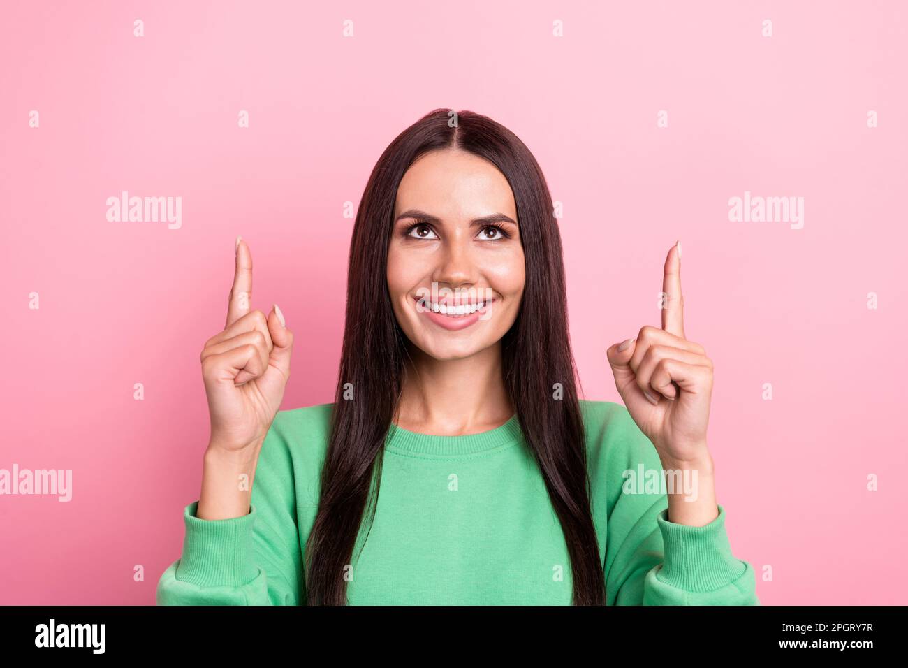 Portrait of satisfied pretty nice girl wear green pullover look empty space directing at discount isolated on pink color background Stock Photo
