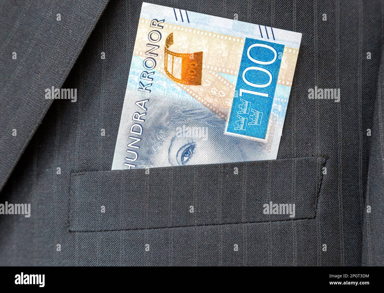 One hundred Swedish krona banknote sticking out of the pocket of a business suit Stock Photo