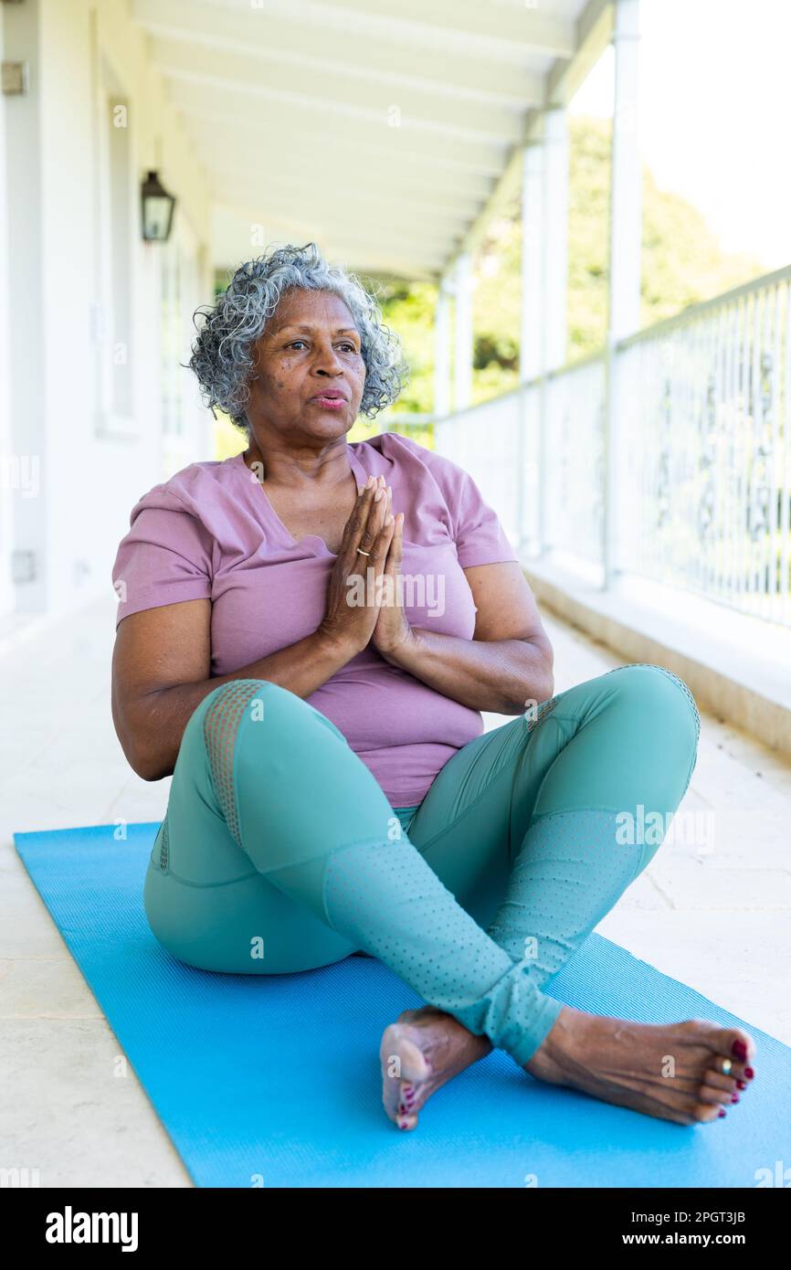 African american senior woman meditating in prayer pose while sitting on  mat in balcony, copy space. Unaltered, lifestyle, retirement, yoga, zen,  exer Stock Photo - Alamy