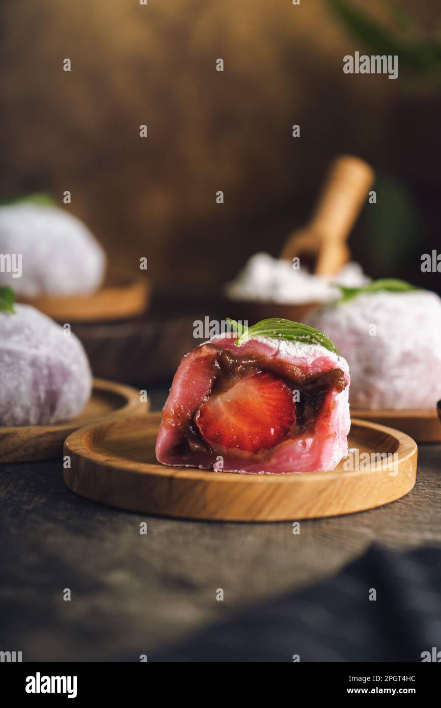 Japanese mochi or rice cake filled with red bean and strawberry, mint leaves on top. Japan traditional rice cake. Stock Photo