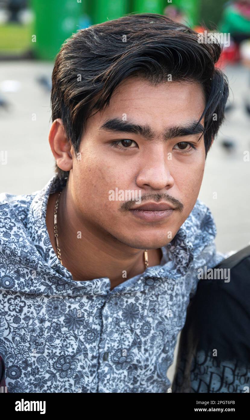 Phnom Penh,Cambodia-December 23rd 2022:Cambodian male teenagers meet up with other teens and family,in the relative cool of early evening,to socialize Stock Photo