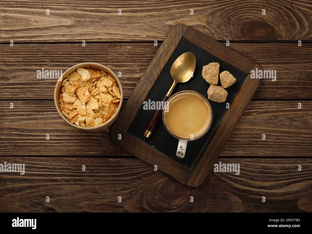 Close up glass cup of espresso coffee and Napoleon mille-feuille vanilla custard slice cake, on black slate over wooden table, high angle view Stock Photo