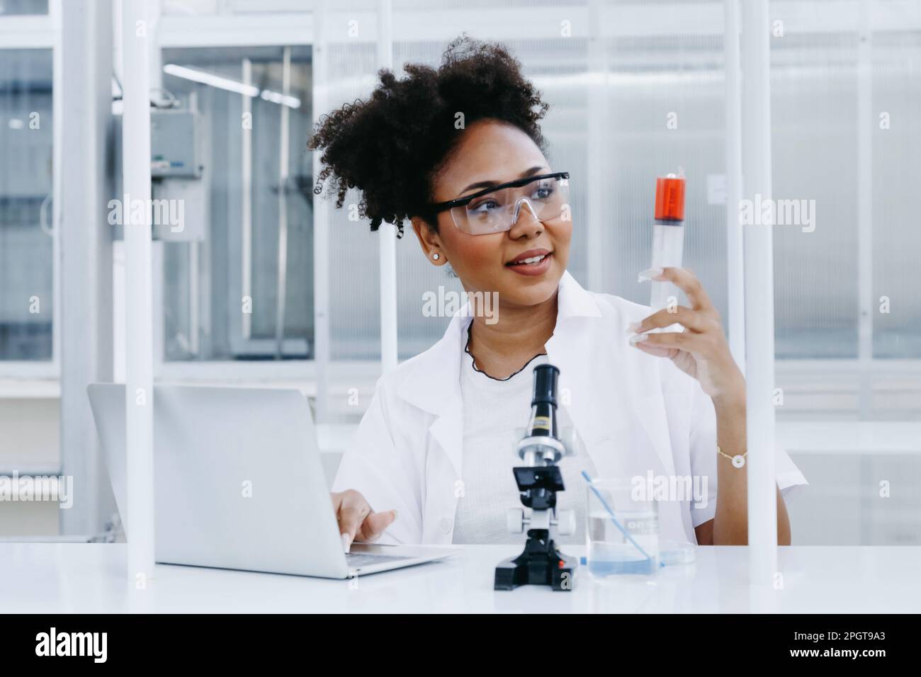 smiling black scientist doctor student studying and experiment analysis test sample with writing report in computer. ambitious young biotechnology Spe Stock Photo