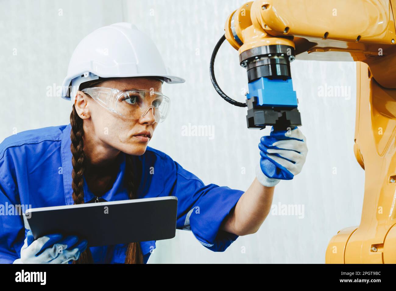 female automation machine engineer student study and inspection control robot arm machine in university or factory workshop. AI robot technology new i Stock Photo