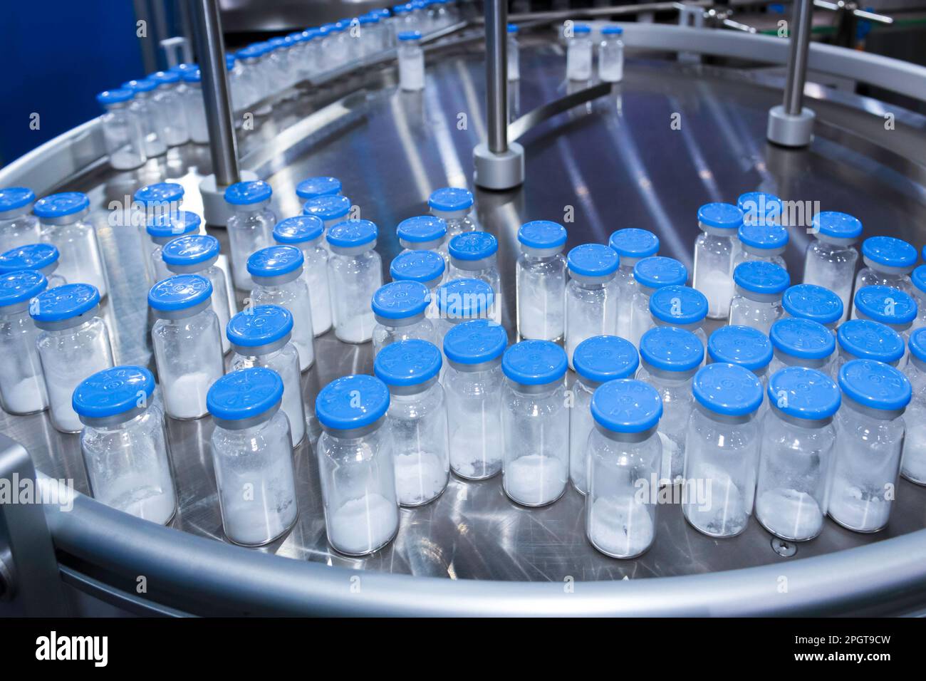 medicine glass bottle in pharmaceutical production line run on conveyor belt at filling machine in medical vaccine manufacturing.  healthcare and medi Stock Photo