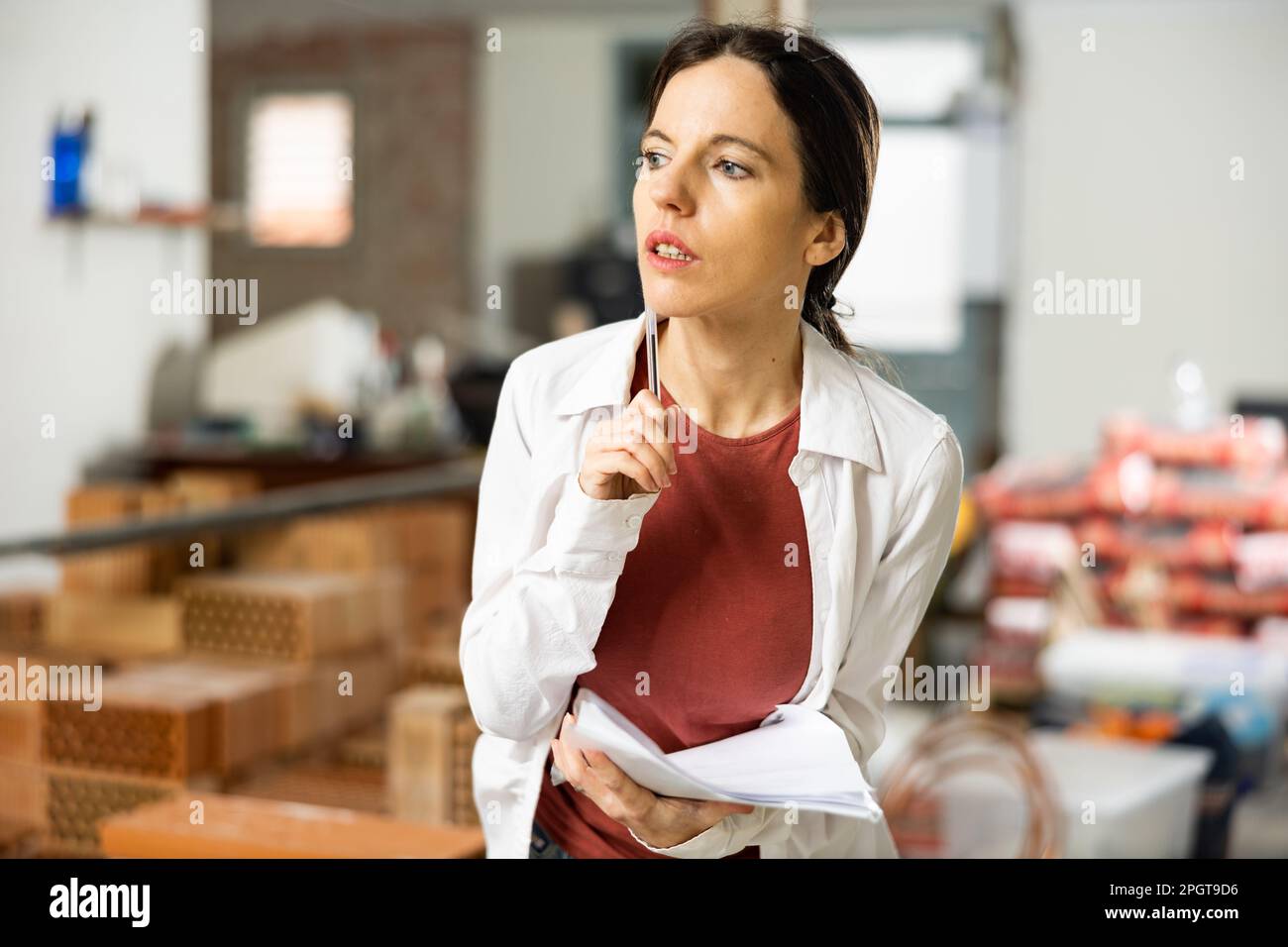 Interested brunette making notes while planning home renovation Stock Photo