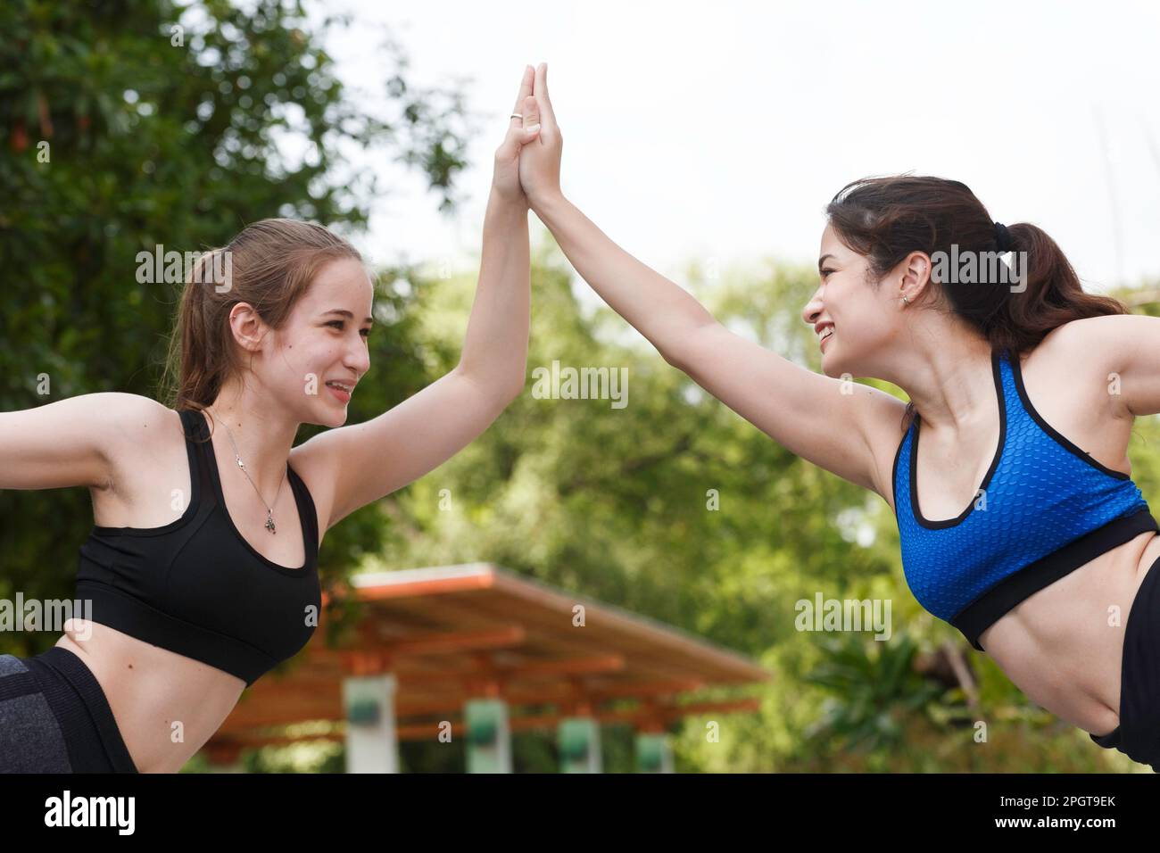 young beautiful teenager practicing yoga or ballet with friend at outdoor garden in summer morning weekend. Healthy lifestyle. Stock Photo