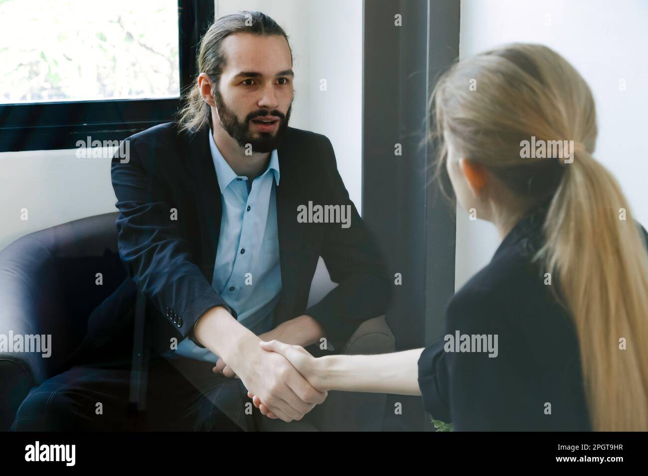Smiling success young businessman talking and interview with secretory or reporter. Business meeting and young entrepreneur. Stock Photo