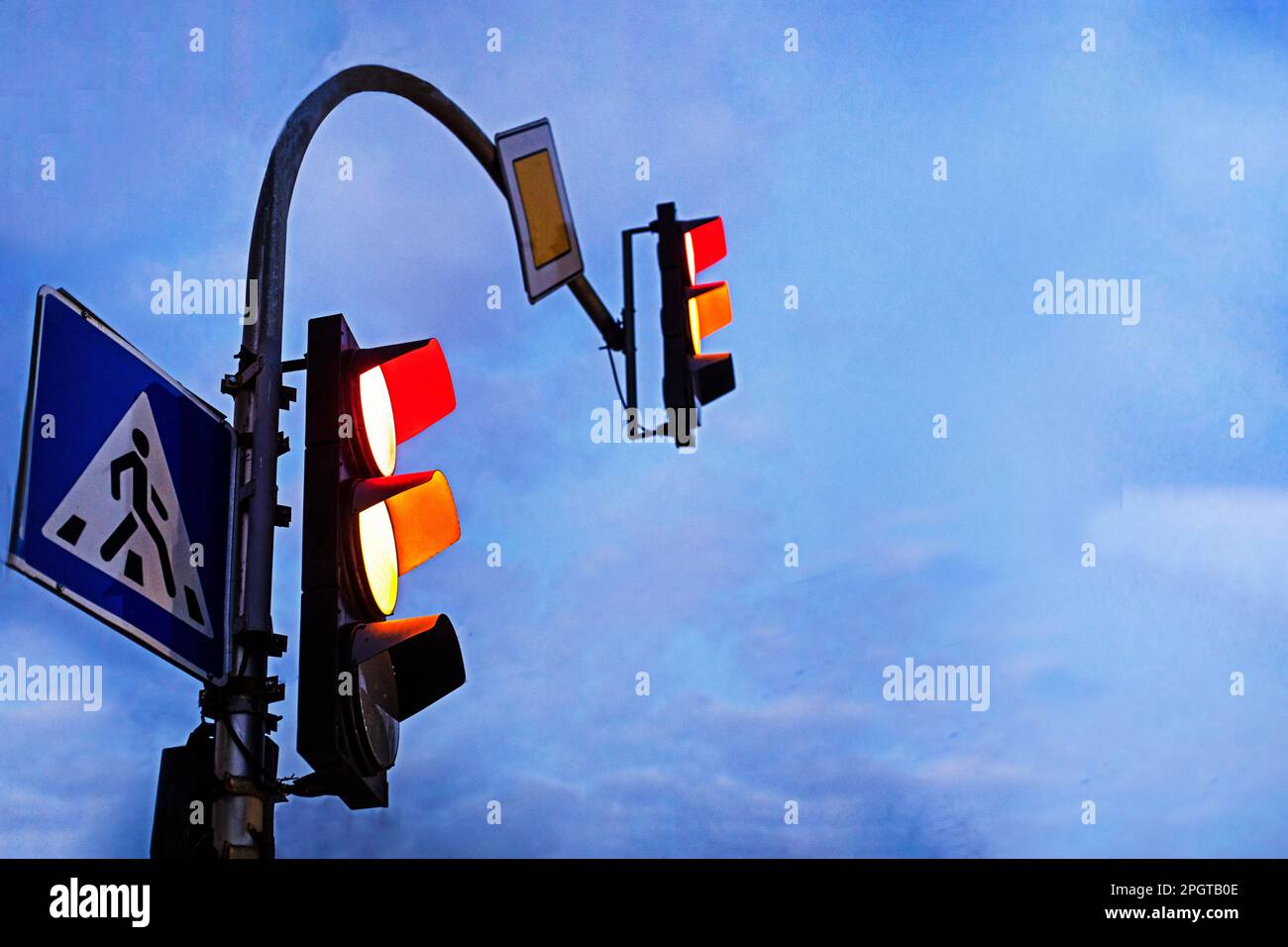 Crossing the city with a traffic light in the evening. Red and orange