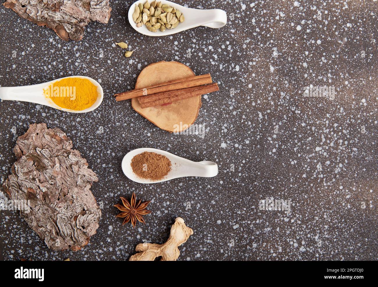 Natural spices of turmeric, cardamom, cinnamon, dried ginger, star anise with copy space. Condiments on black background. Stock Photo